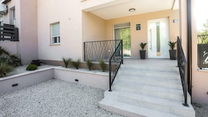 A building entrance with a staircase, a metal railing, and a door with a sign above it. - Beautiful home in Nova Vas (Nova Vas)