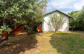 Ein Haus mit Garten, einem Weg und einem kleinen Baum.