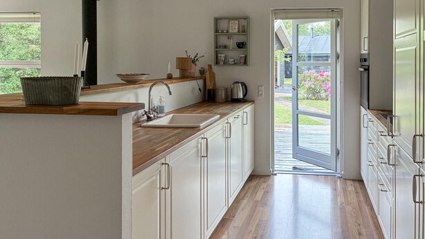 A kitchen with a wooden countertop, a sink, and cabinets. There is a door leading outside. - Cozy home in Silkeborg with WiFi (Silkeborg)