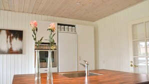 A kitchen with wooden countertops, a stainless steel sink, and a refrigerator.