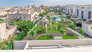 A rooftop pool area with a pergola, surrounded by greenery and modern buildings. - Beautiful apartment in Torrevieja with WiFi (Torrevieja)