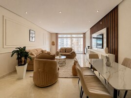 Una sala moderna con un sofá, sillones, una mesa de centro y una mesa de comedor.