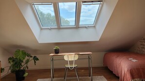 A bedroom with a skylight, a desk, a chair, a bed, a potted plant, and a bedside table. - Tastefully renovated 18th century farmhouse, landscaped gardens and access to the château grounds (Treillières)