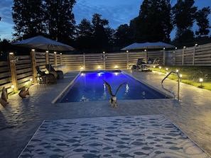A swimming pool with a bird, surrounded by wooden fences, chairs, and umbrellas. - The Lodge @ Lake Cumberland  
For Families and Friends! (Jamestown)