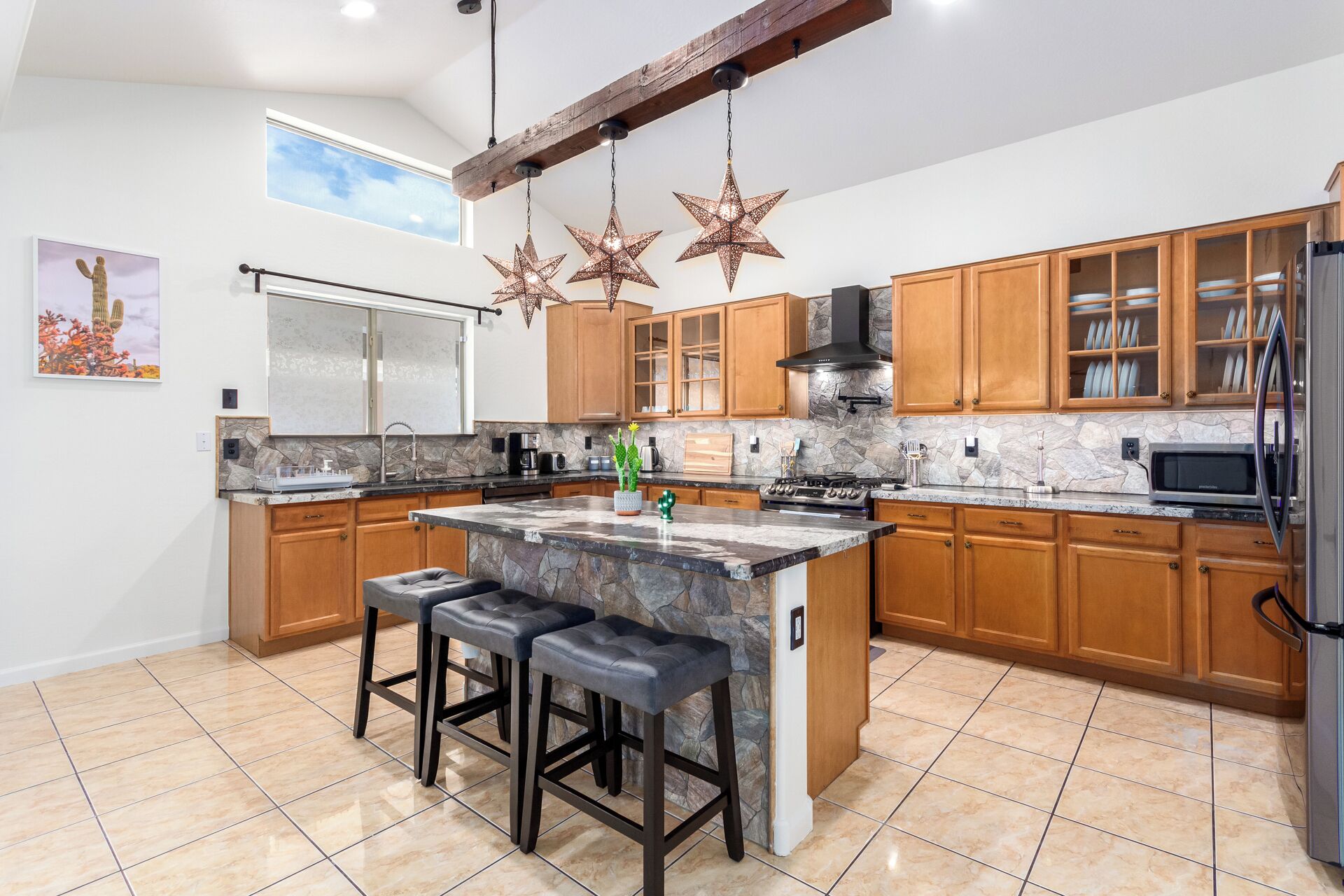Una cocina moderna con una isla grande, armarios de madera y salpicadero de piedra.