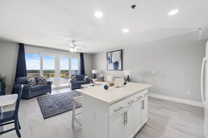 Un salon moderne avec un canapé, une table basse et une vue sur l’extérieur.