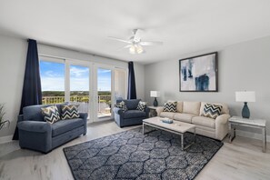 A living room with two sofas, a coffee table, and a ceiling fan. - Laketown Luxury| Unit 935| Fully Renovated (Panama City Beach)
