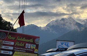 A sign for the New Siddharth Hotel with amenities listed, including breakfast, lunch, and dinner. - Siddharth New Hotel byLowBazar Joshimath (Joshimath)