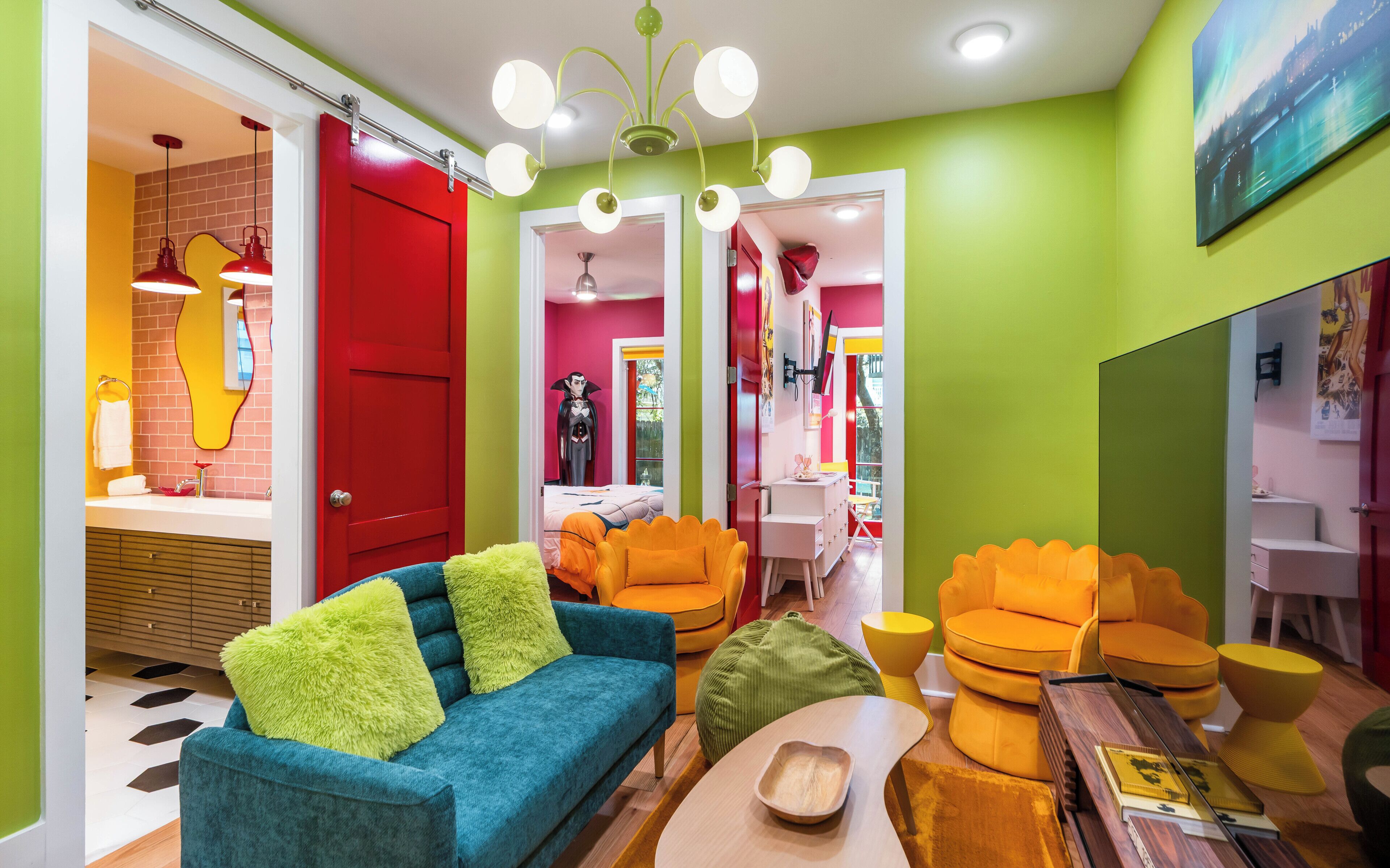 A vibrant living room with a blue sofa, orange chairs, and a wooden coffee table.