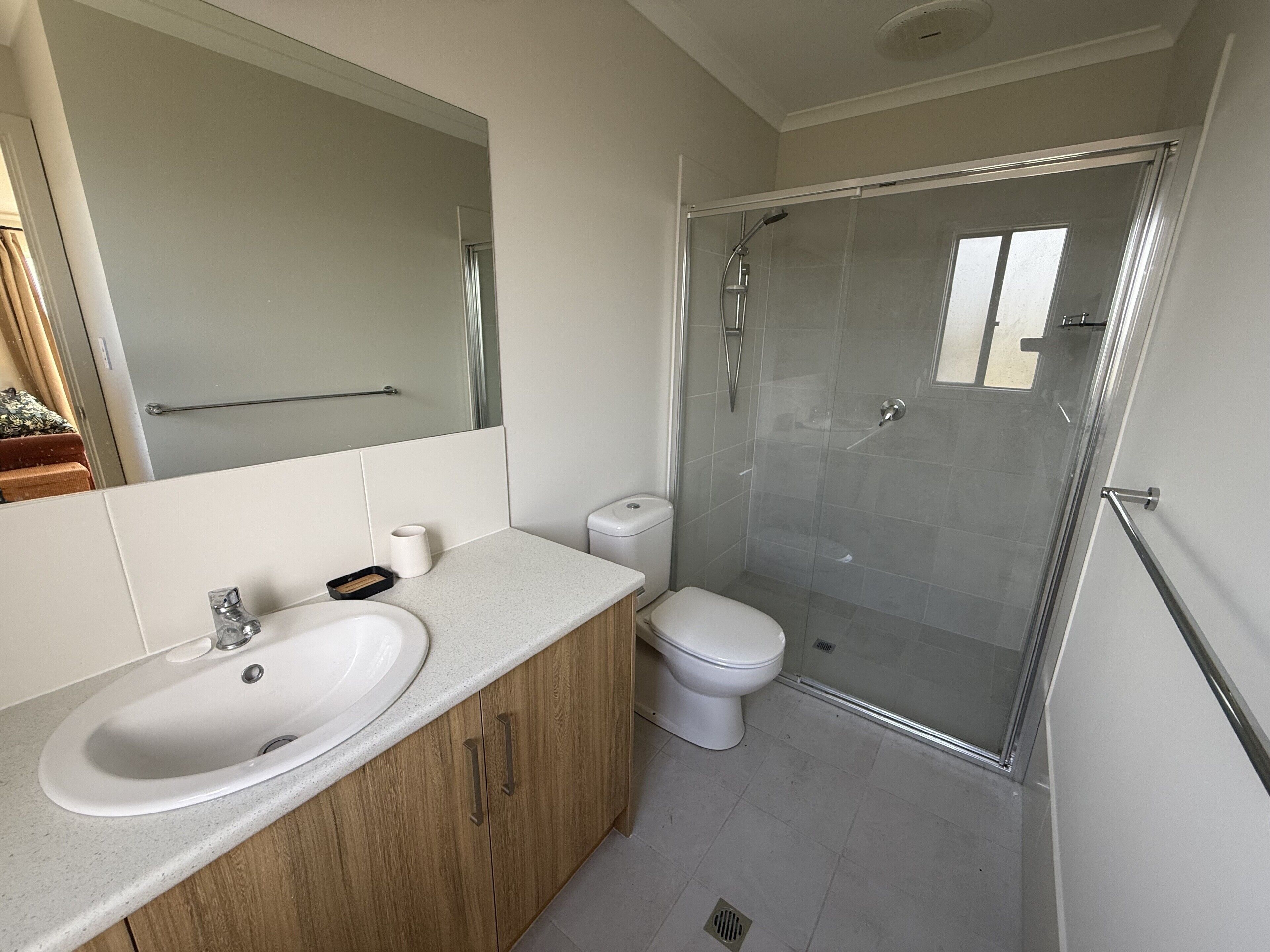 A modern bathroom with a glass shower enclosure, a white sink, and a toilet.