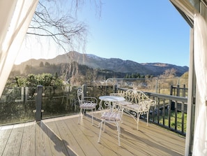 A wooden deck with outdoor seating and a view of mountains. - Hollybirch (Crieff)