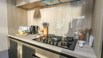 A modern kitchen with a gas stove, a toaster, and a coffee maker.