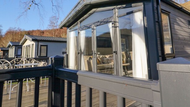 A modern house with a large glass window and a balcony.