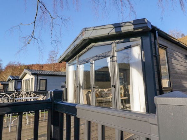 A modern house with a large glass window and a balcony.