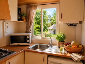 A compact kitchen with a microwave, sink, and stove.