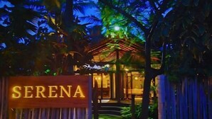 Una entrada con puerta y señalización que dice 'SERENA' de noche.
