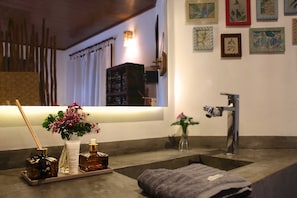 Un baño con lavabo, toalla y artículos de aseo.