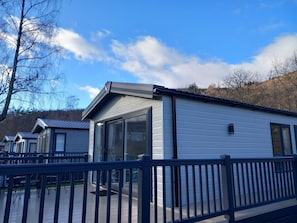 A row of mobile homes with large windows and a deck area.
