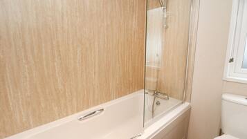A bathroom with a bathtub, a shower, and a toilet.
