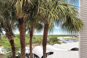 A view of a building with multiple white dome-shaped structures, palm trees, and a body of water in the background. - 🌴 Short Walk to Beach - Pet Friendly - Living the Dream ☀️ (Mexico Beach)