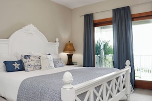 A neatly made bed with a patterned bedspread, a decorative headboard, and a bedside lamp. - 🌴 Short Walk to Beach - Pet Friendly - Living the Dream ☀️ (Mexico Beach)