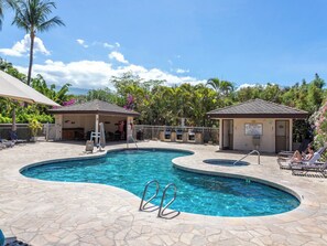 A pool area with two sun shelters, lounge chairs, and a clear blue pool. - Maui Banyan G-105 | Lush Oasis + Steps to Beach! (Kihei)