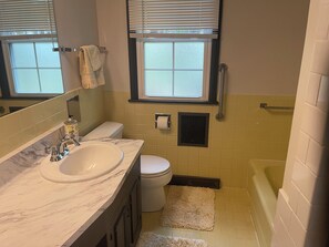 Ein Badezimmer mit Waschbecken, Toilette und Badewanne.