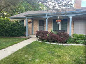 A residential house with a brick facade, a front porch, and a pathway leading to the entrance. - Peaceful 2-bedroom brick Shorewood house near Lake Michigan beaches. (Shorewood)