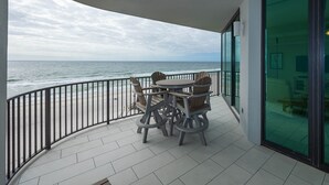 A balcony with a table and chairs, overlooking the ocean. - Phoenix Ix 607 2 Bedroom Condo (Orange Beach)