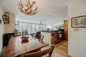 Eine moderne Küche mit Essbereich, Holzschränken und einer Kristallleuchter.