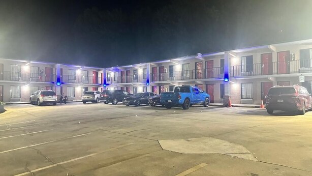A multi-story motel with a parking lot. - Regency Inn (Riverdale)
