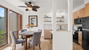 A modern kitchen with a black refrigerator, wooden cabinets, and a built-in microwave. - Kauai Kahala At Poipu Kai 212 1 Bedroom Condo (Koloa)