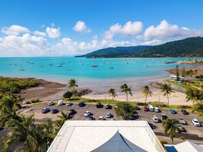 A coastal view with a parking lot, beach, and boats on the water. - Airlie Beach Penthouse (Airlie Beach)