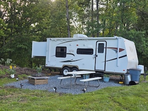 A recreational vehicle with a kitchen area, a sleeping area, and a bathroom.