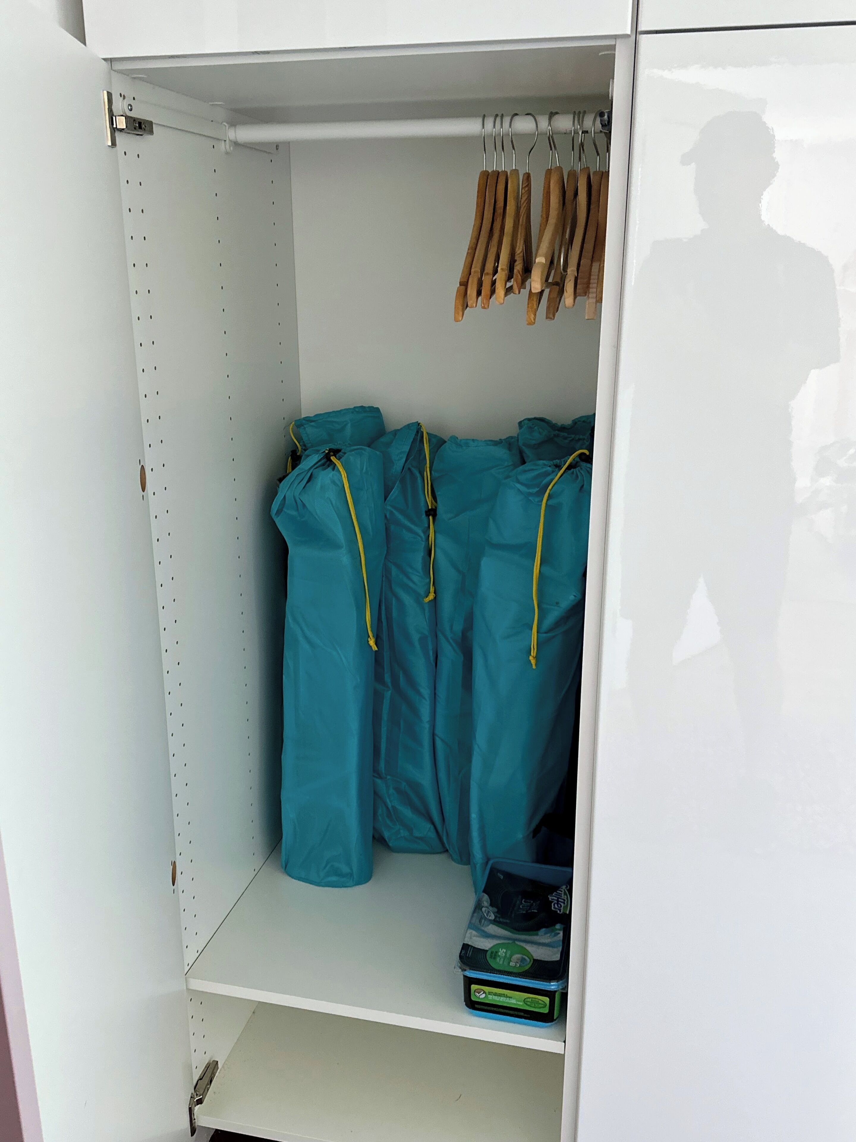 Ein weißer Kleiderschrank mit Kleiderstange und Ablagefläche.