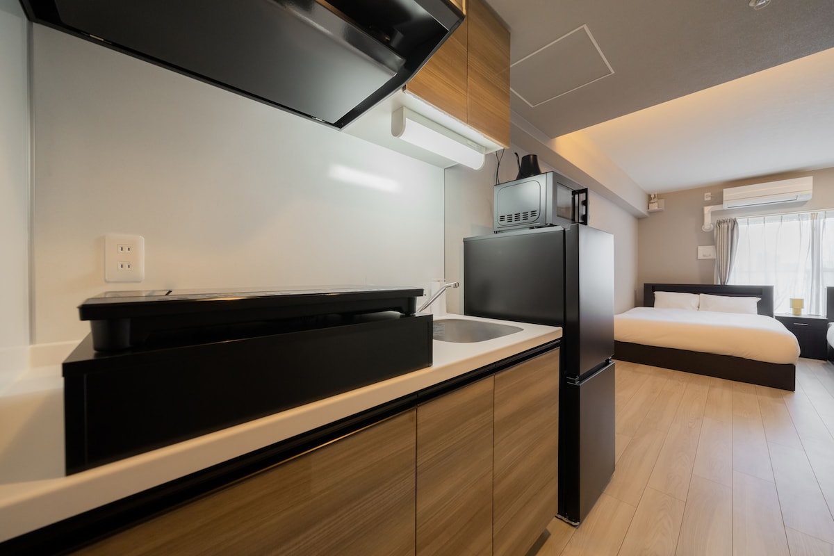 Eine kleine Küche mit Kühlschrank, Mikrowelle und Spüle.