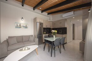 Eine moderne Küche mit Essbereich, einer Couch und einem Gemälde an der Wand.
