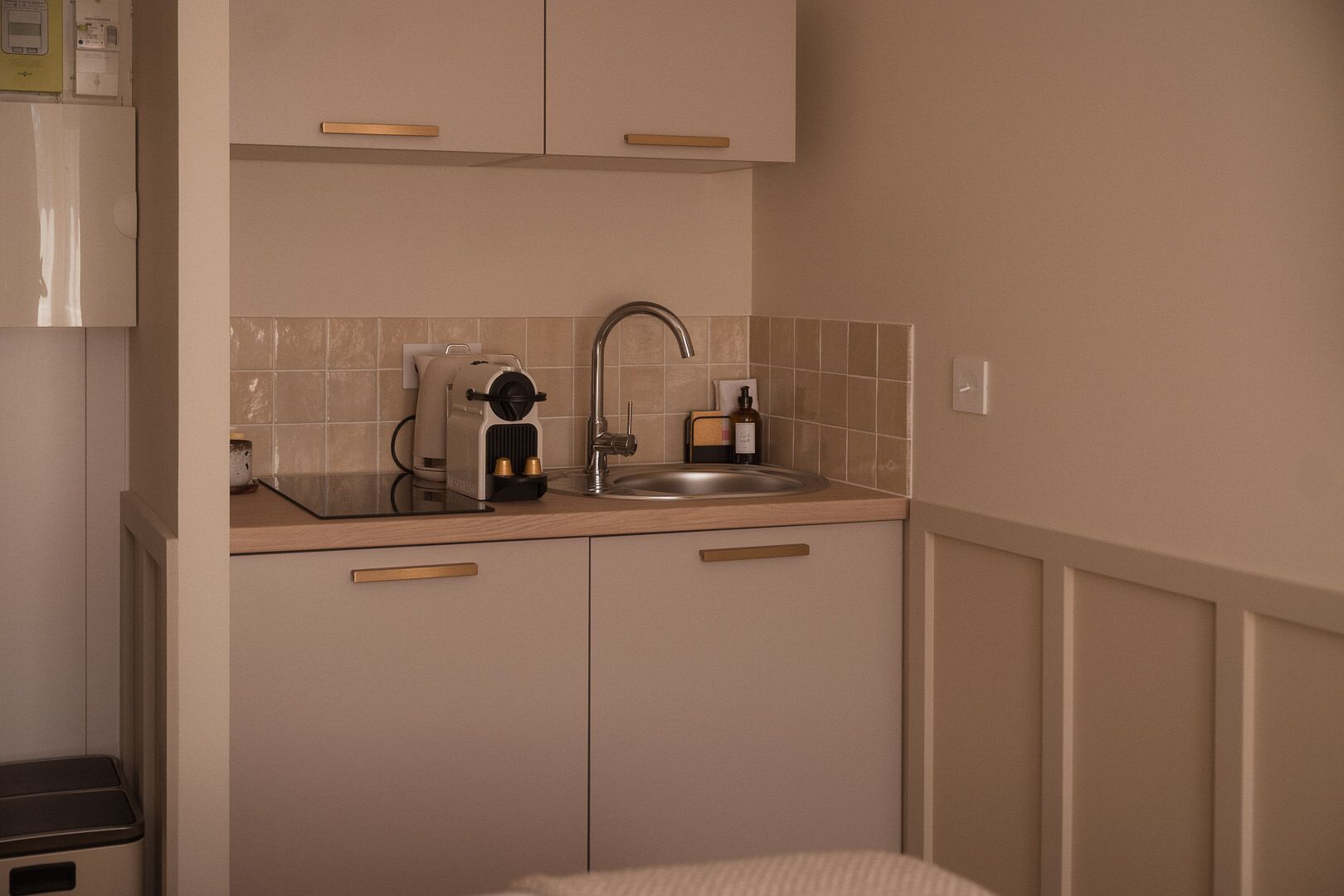 A compact kitchenette with a sink, a coffee maker, and a small countertop.