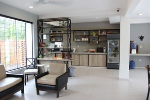 Una cocina moderna con estantes empotrados, un refrigerador y un comedor con sillas.