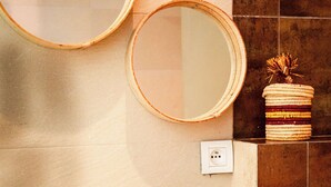A bathroom with a white sink, two faucets, a mirror, and a wall-mounted outlet. - Waterfront Apartment - Ocean View (Essaouira)