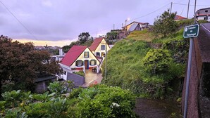 A hillside residential area with houses, a pathway, and a sign indicating 'Caminho do Vinhatagai.' - Grandfather's House (Santana)
