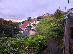 A hillside residential area with houses, a pathway, and a sign indicating 'Caminho do Vinhatagai.' - Grandfather's House (Santana)