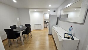 A modern kitchen with white cabinets, a refrigerator, and a microwave. - Grandfather's House (Santana)