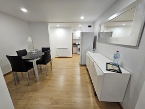 Eine moderne Küche mit weißen Schränken, einem Kühlschrank und einer Mikrowelle.
