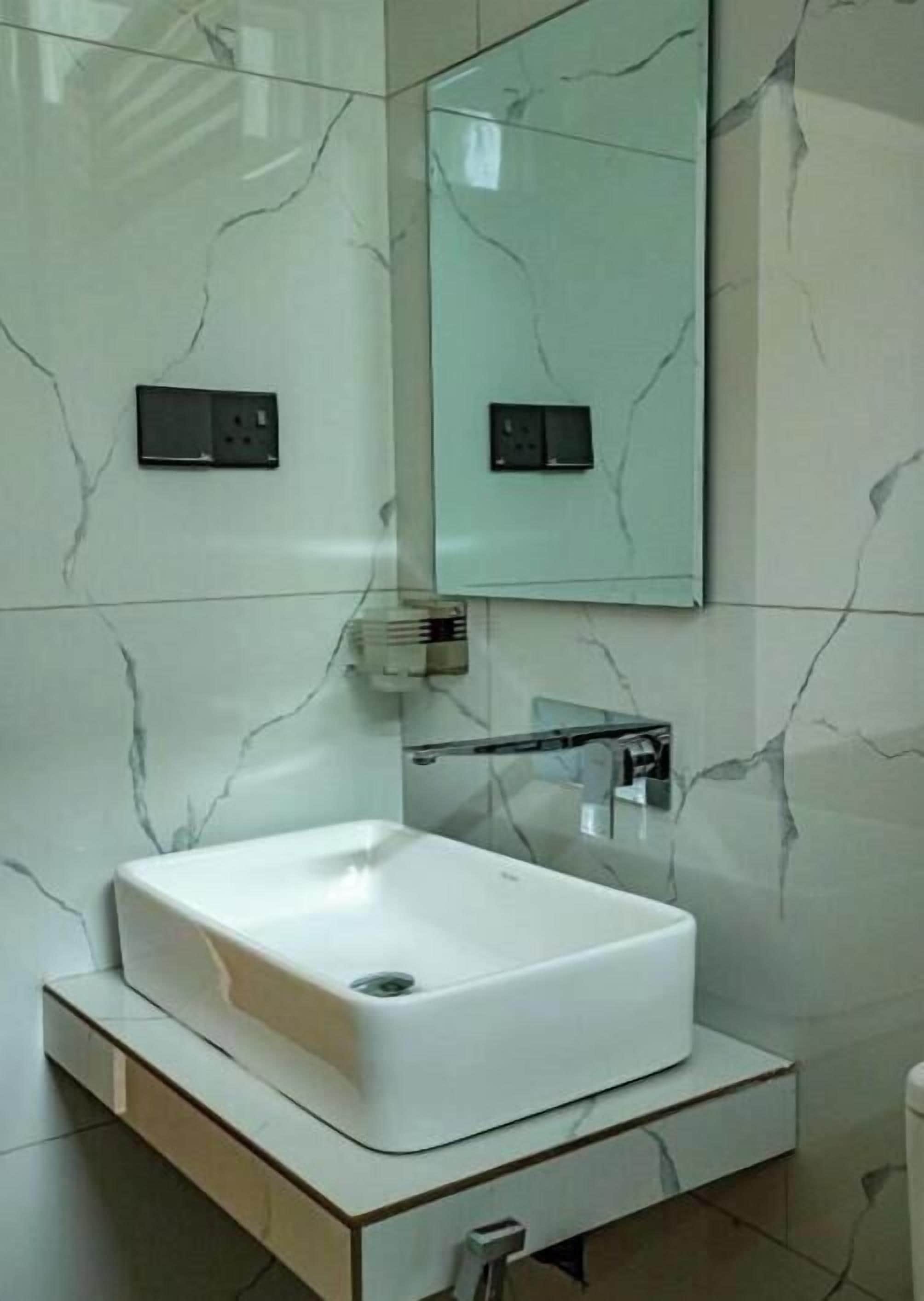 A bathroom with a white sink, a mirror, and a towel rack.