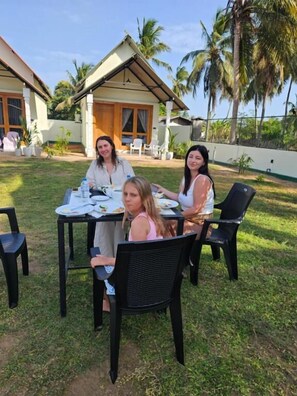 Zona pranzo con tavolo, sedie e un edificio con tetto spiovente sullo sfondo.