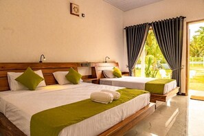 Camera d'albergo con due letti, una testiera in legno, un comodino, una lampada e vista sull'esterno.