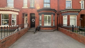 A two-story brick house with a front entrance, a small porch, and a paved driveway. - Contractor, Families, Free Parking, Private Garden (Worsley)