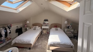 A bedroom with two beds, a desk, a wardrobe, and skylights. - Contractor, Families, Free Parking, Private Garden (Worsley)