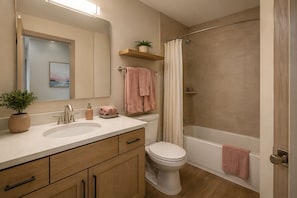 Ein Badezimmer mit Waschbecken, Toilette, Dusche und Spiegel.